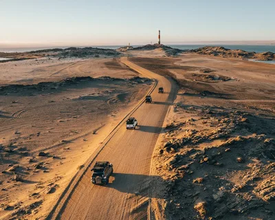 Convoy of 4x4s on a desert coast road