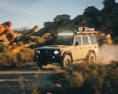 Land Cruiser kicking up dust on a gravel road
