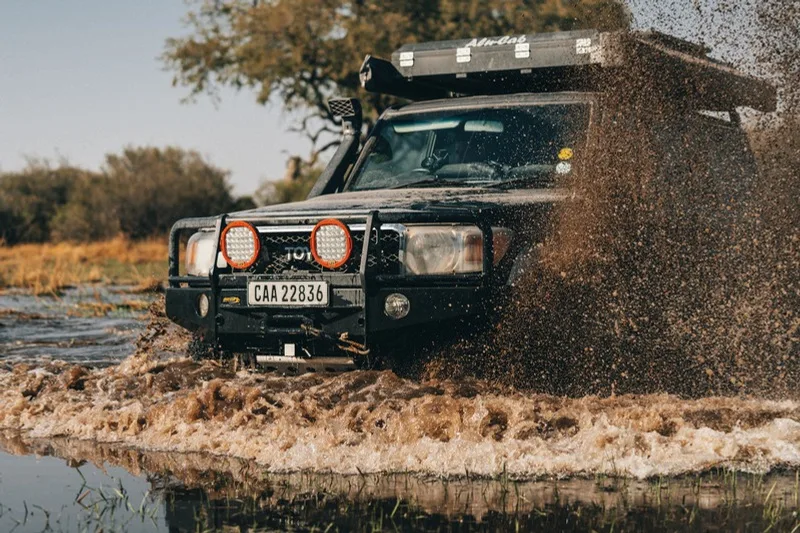 Land Cruiser pushing through a muddy river crossing